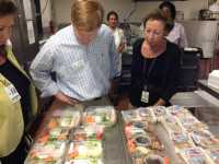 Adam Putnam inspecting school lunch trays