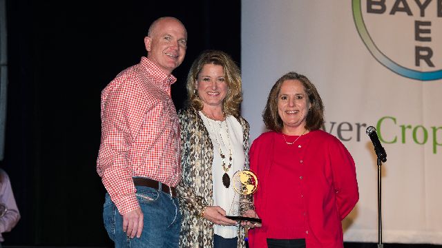 Lori Anne Carr, center, along with her husband, Chalmers Carr III, received the first ever Produce Innovation Award. She is flanked by David Hollinrake and Inci Dannenberg of Bayer CropScience. 