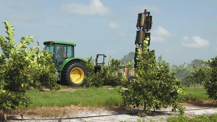 sprayer applying bactericides to citrus trees