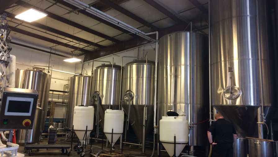 Vats of craft beer at 3 Daughters Brewing