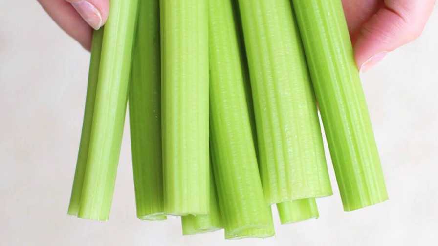 hands holding a stack of cut celery