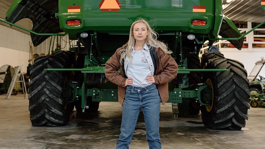 Zoe Kent in front of large farm equipment